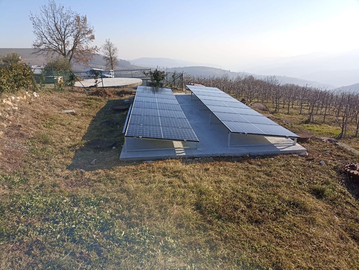 Impianto fotovoltaico a terra su doppia fila, colline sullo sfondo