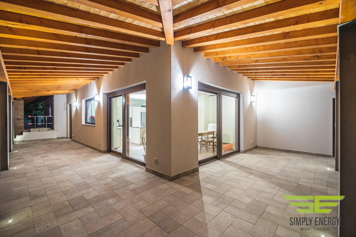 Portico con travi in legno e illuminazione progettata