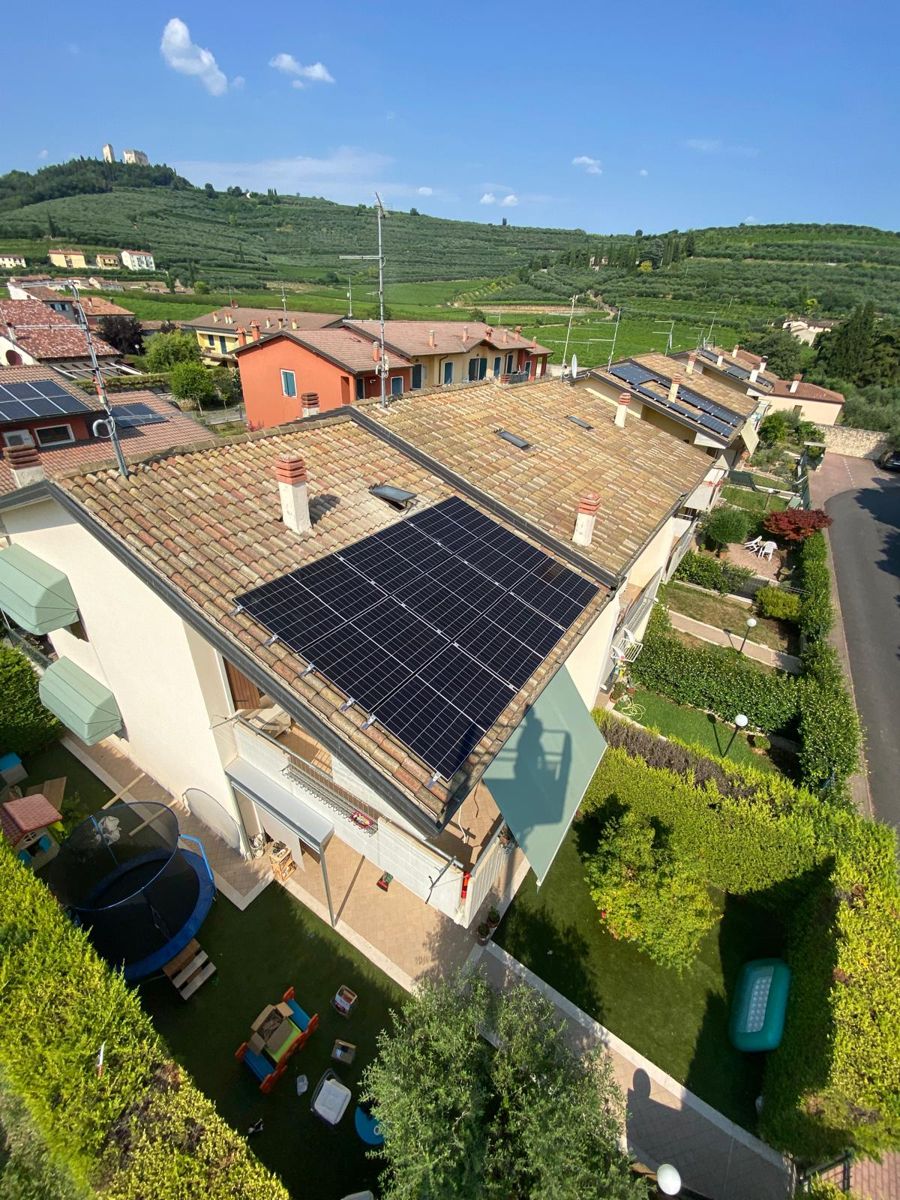 Impianto fotovoltaico su una villetta a schiera, vista aerea della collina
